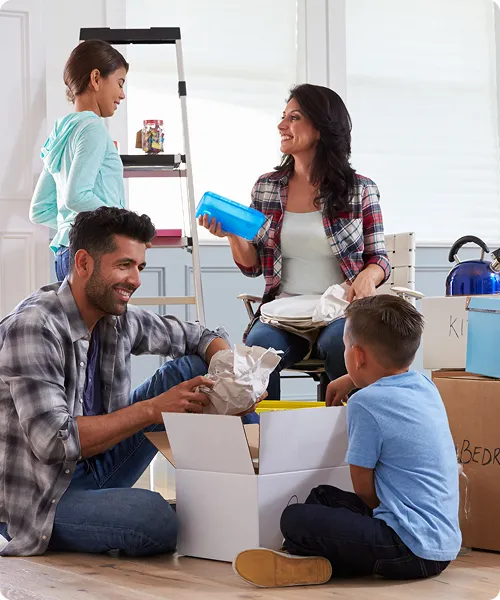 Familia feliz desempacando cajas en su nuevo hogar