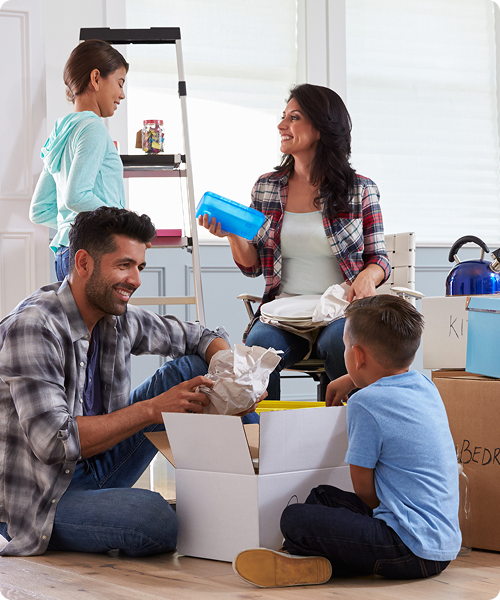 Familia feliz desempacando cajas en su nuevo hogar